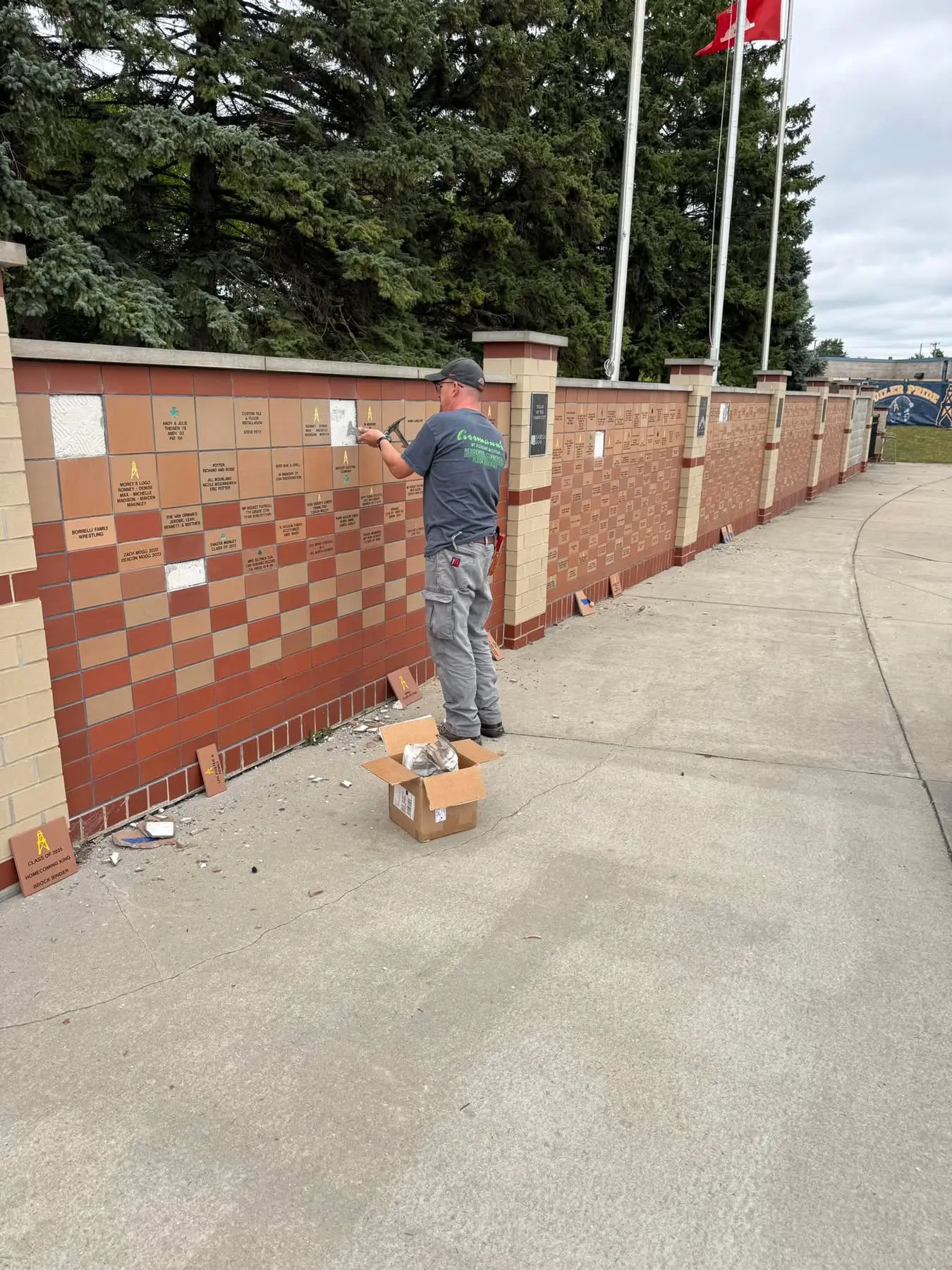 Engraved donor bricks being set into the wall along the stadium walkway